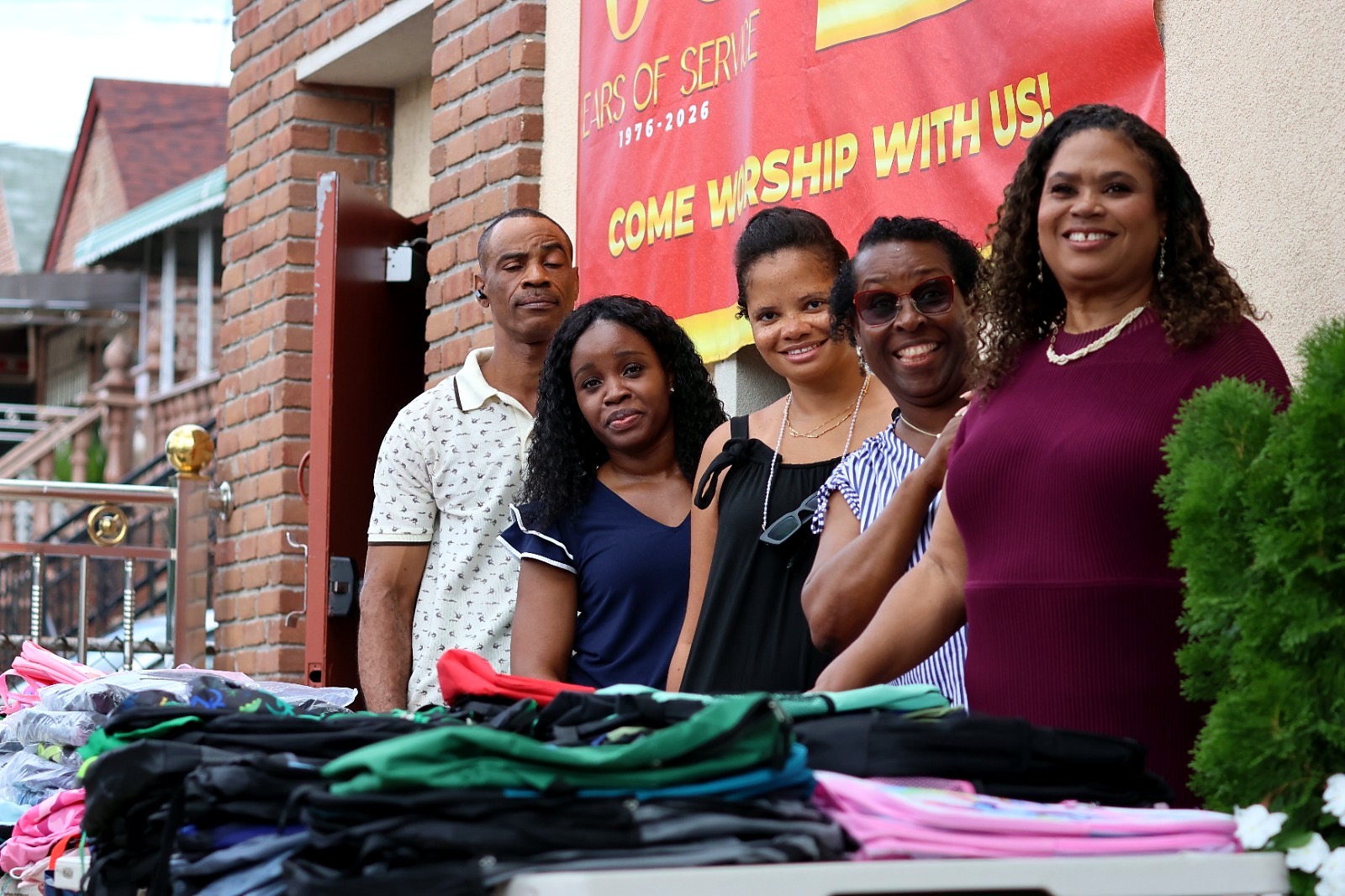 Foundation supporters stand with book bags and school supplies prepared for children.