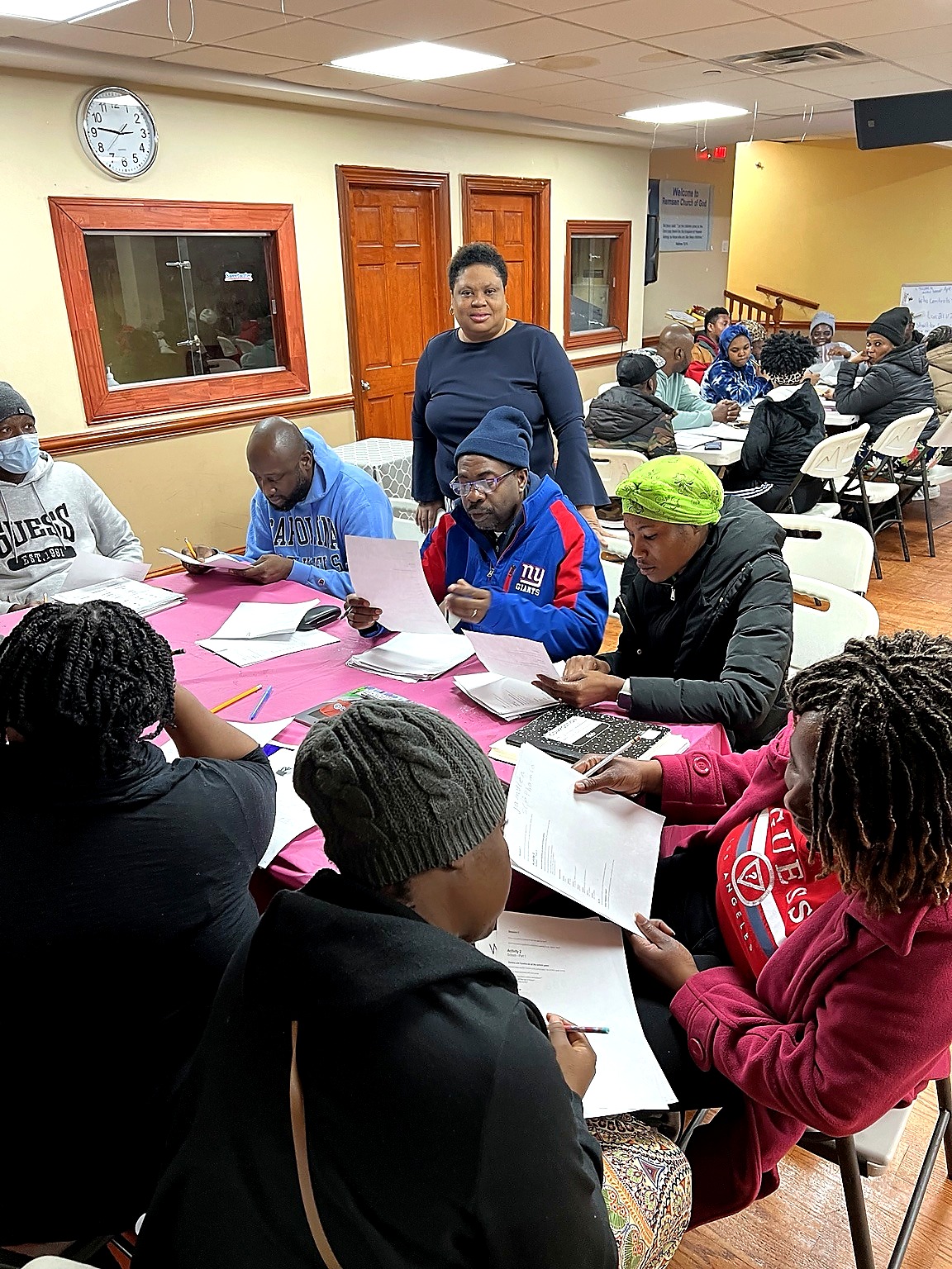 Adult learners receive focused support in a small ESL learning group.