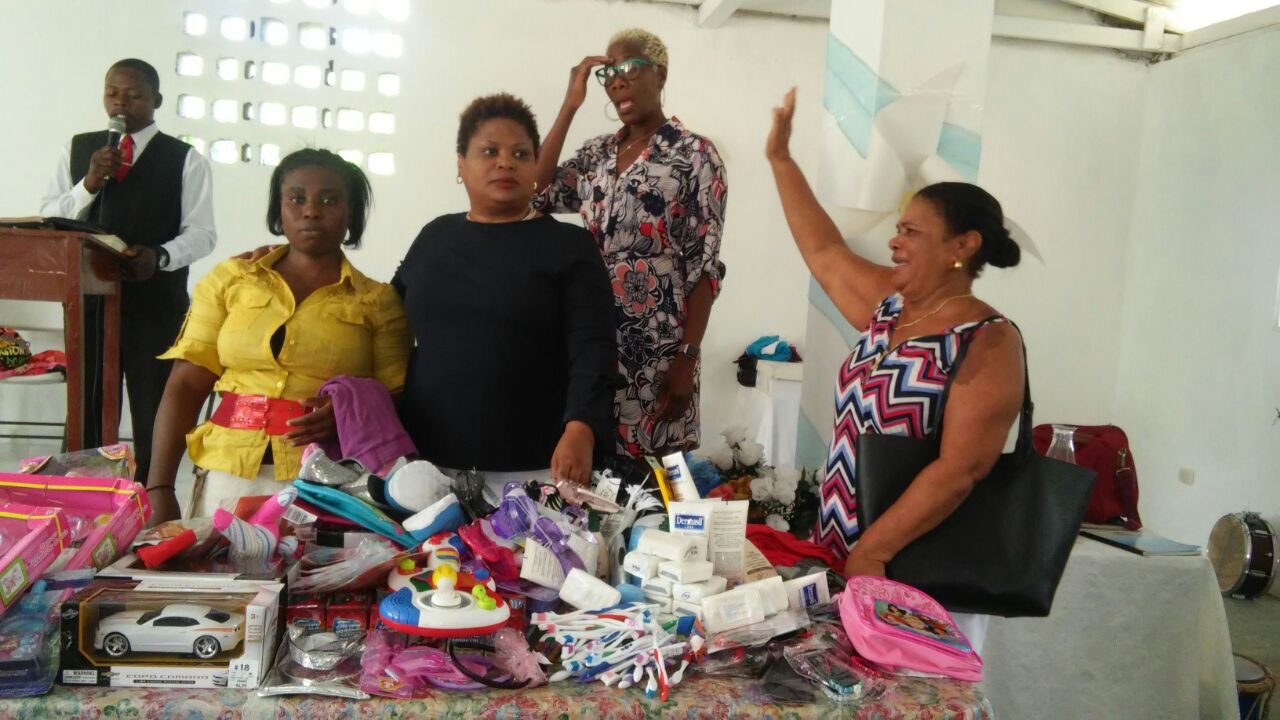 Community volunteers gathered behind a table of essential supplies